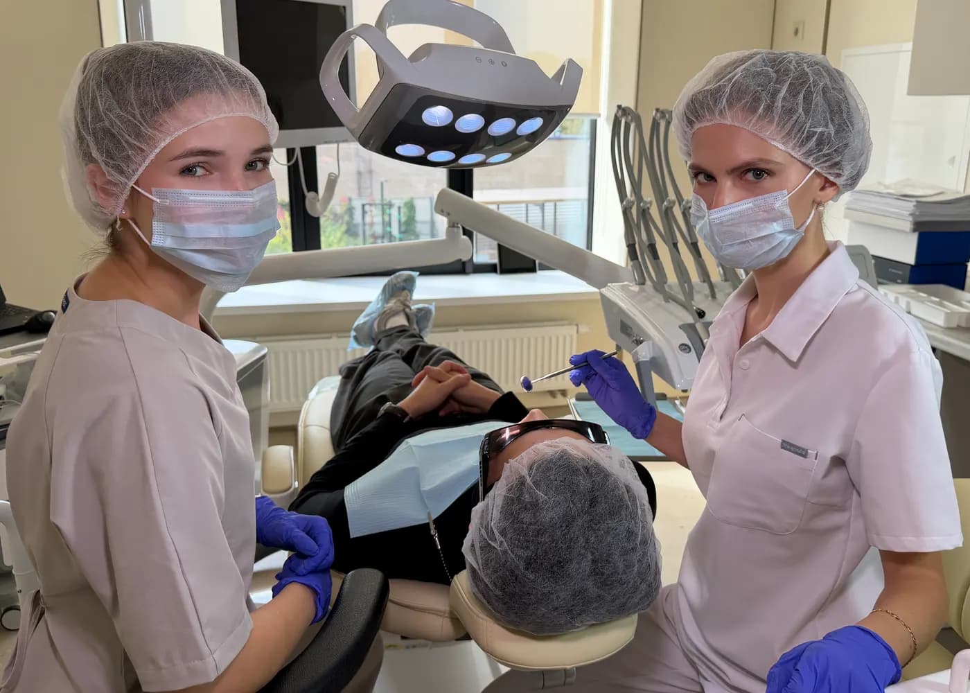 Dental assistants next to a patient in the chair