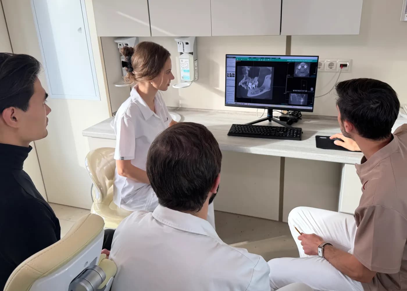 Doctors reviewing a CT scan on a monitor