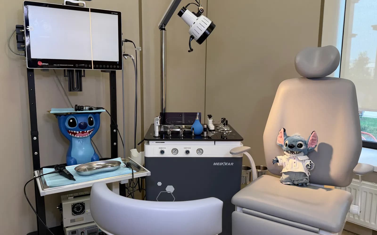 Children's ENT room: endoscopy stack, ENT treatment unit and a chair with a toy