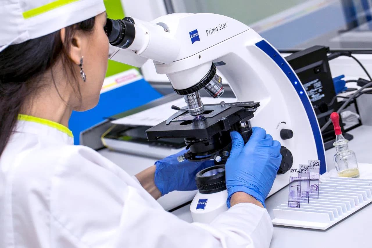 A lab technician working at a microscope in the Labquest laboratory